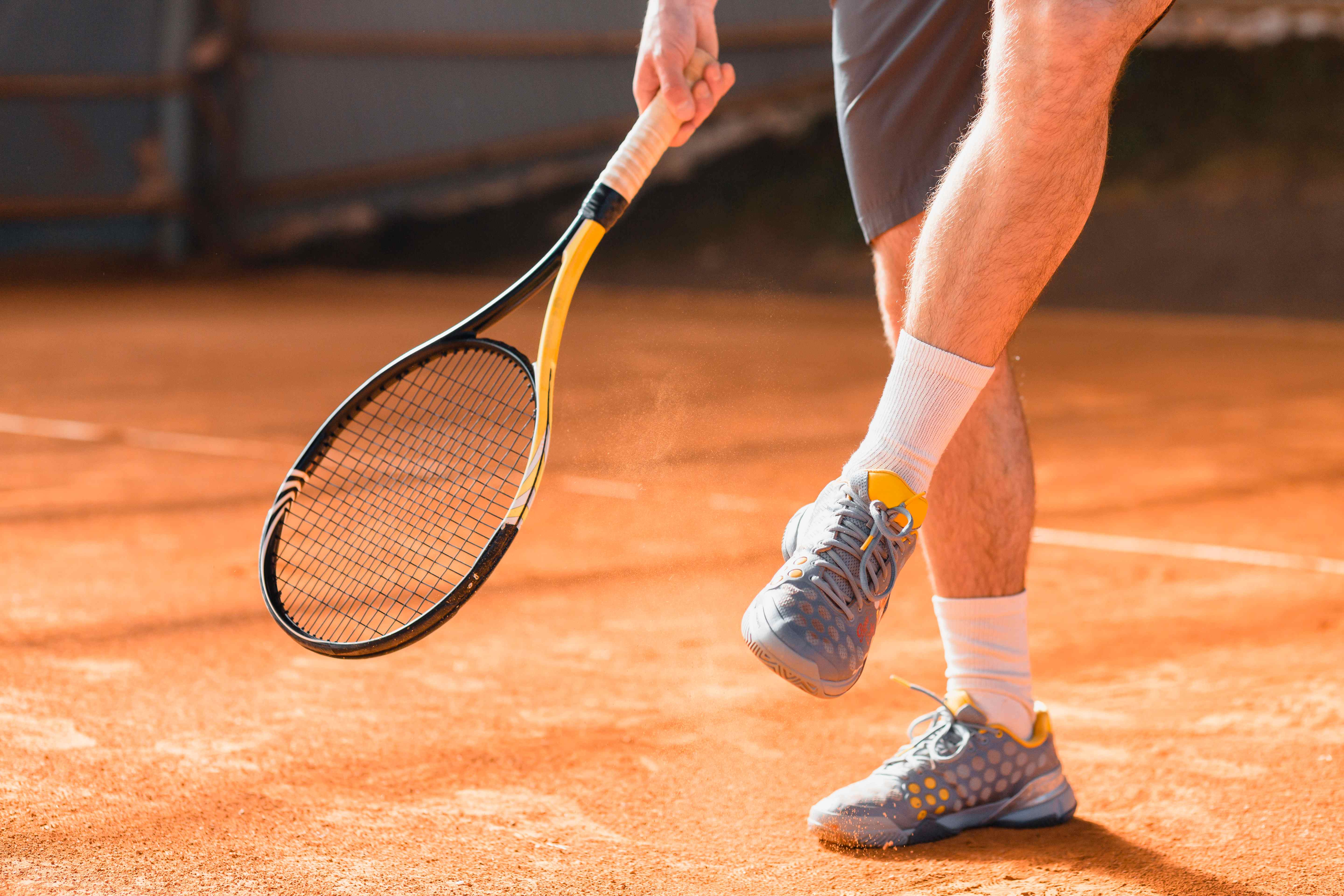 Joueur de tennis sur terre battue avec raquette professionnelle